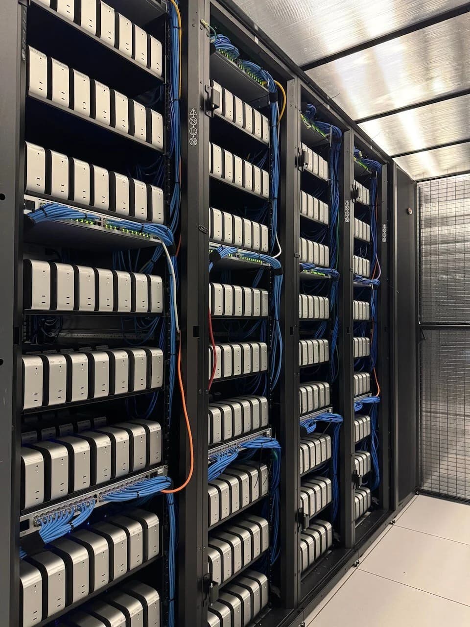 Racks filled with rows of Mac minis, neatly cabled with blue network cables